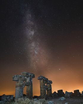 Milky Way over ancient stone ruins in Uşak, Türkiye creating a breathtaking night scene.
