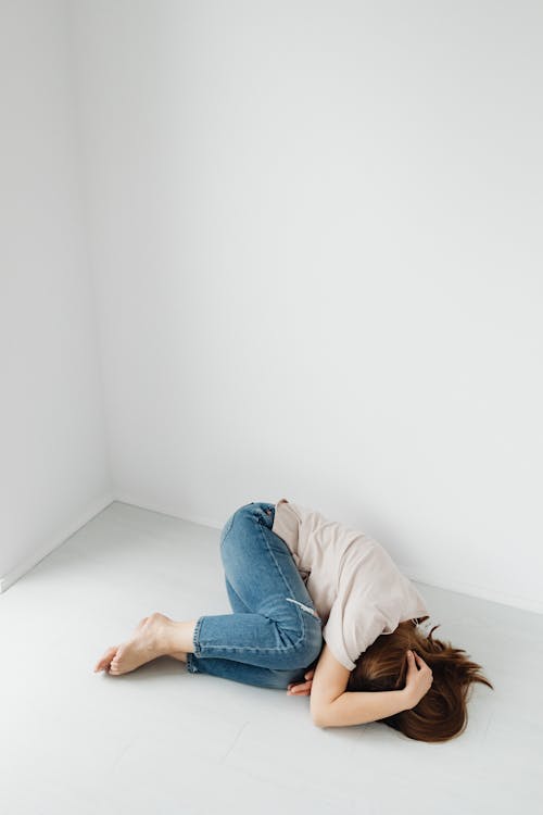 Free Woman Lying Curled up on Floor Stock Photo