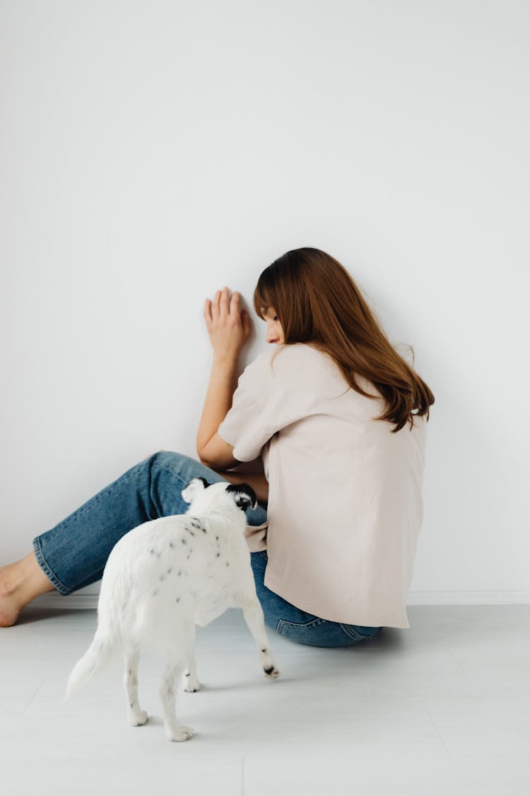 Photograph Of A White Dog Near A Scared Woman