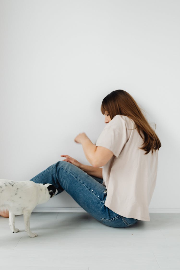 Photo Of A Woman In A Beige Shirt Scared Of A Dog