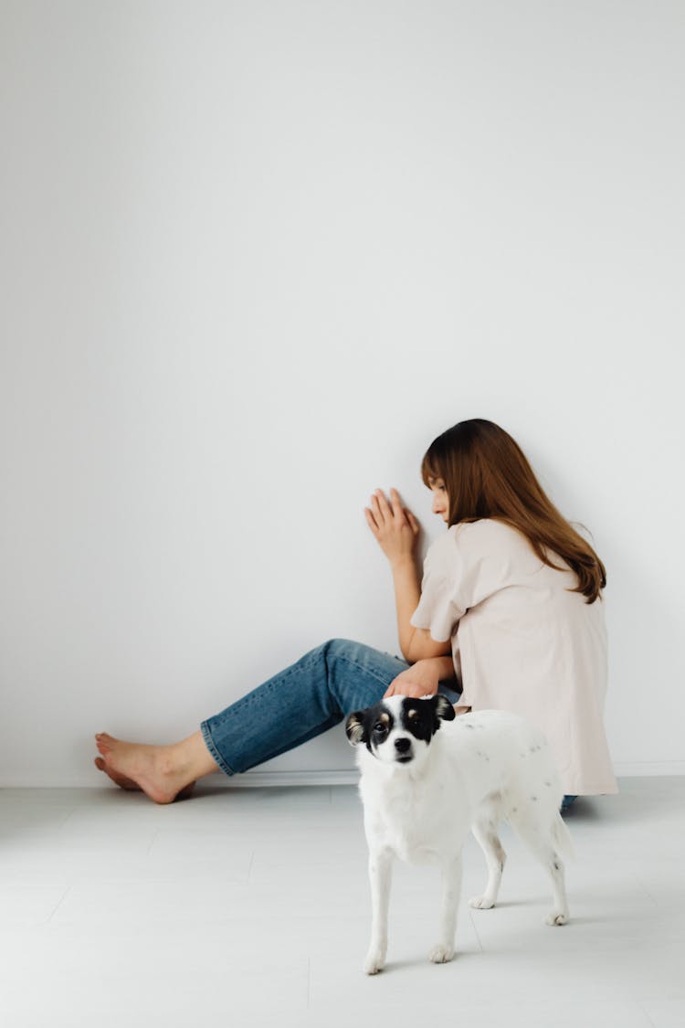 Photograph Of A Woman Afraid Of A White Dog