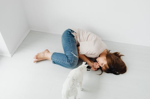 Free Photo of a Woman Sleeping Beside a White Dog Stock Photo