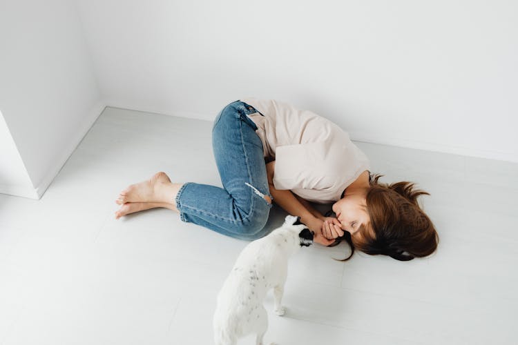 Photo Of A Woman Sleeping Beside A White Dog