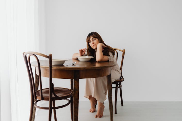 Sad Woman Sitting At The Table