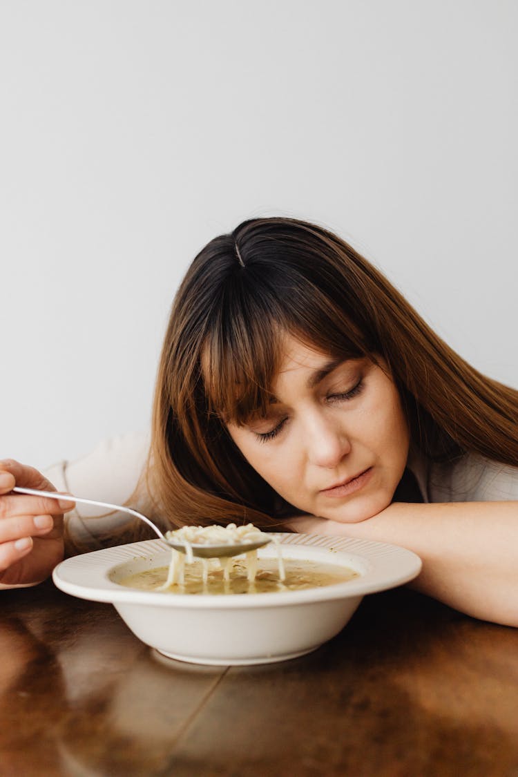 A Woman Eating A Soup