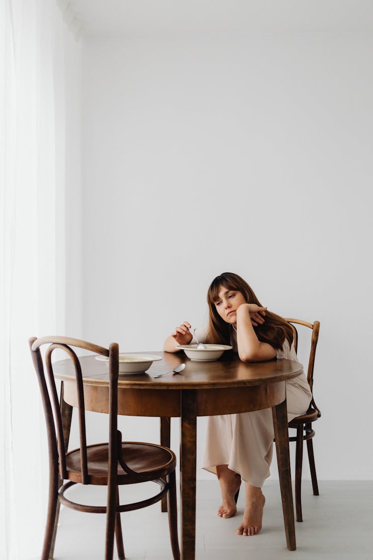 Sad Woman Sitting Alone At The Table