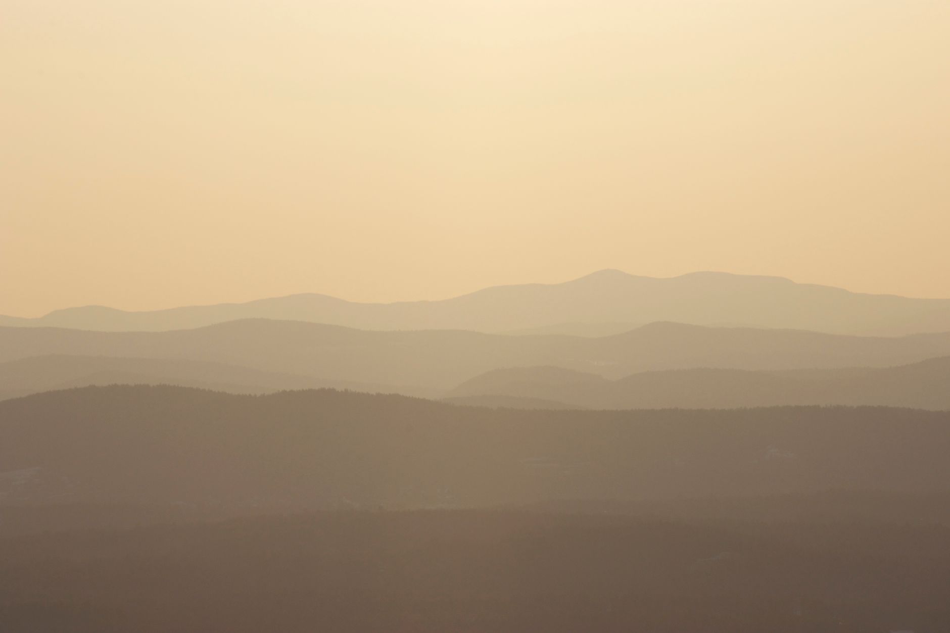 Peaceful dawn landscape with layers of misty mountain ranges under a warm glow.. pexels, peaceful, dawn