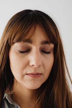Close-up portrait of a serene woman with closed eyes, conveying calmness and introspection.