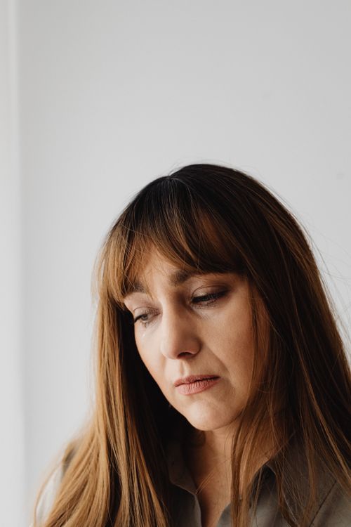 Free Close-up of a brunette woman appearing pensive and serious indoors. Stock Photo