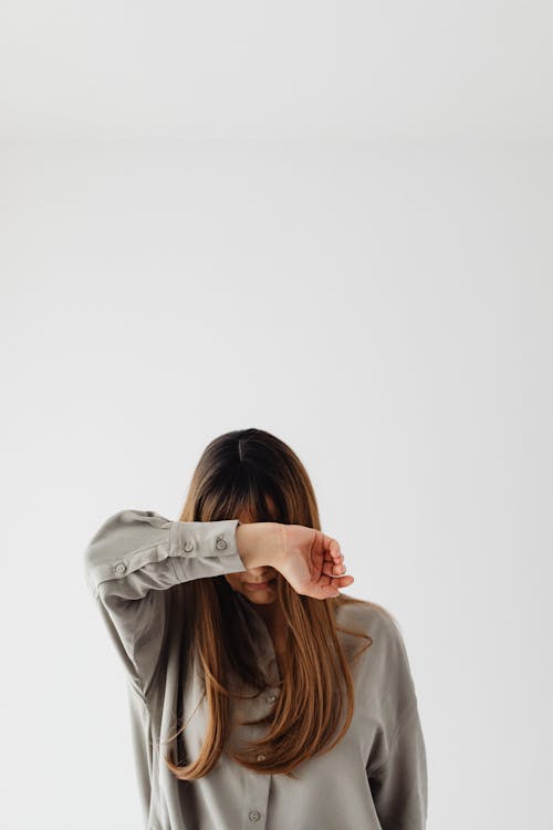 Woman in Gray Long Sleeve Shirt Covering Her Face