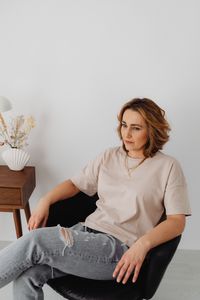 Woman seated in a low chair by kaboompics.com on Pexels