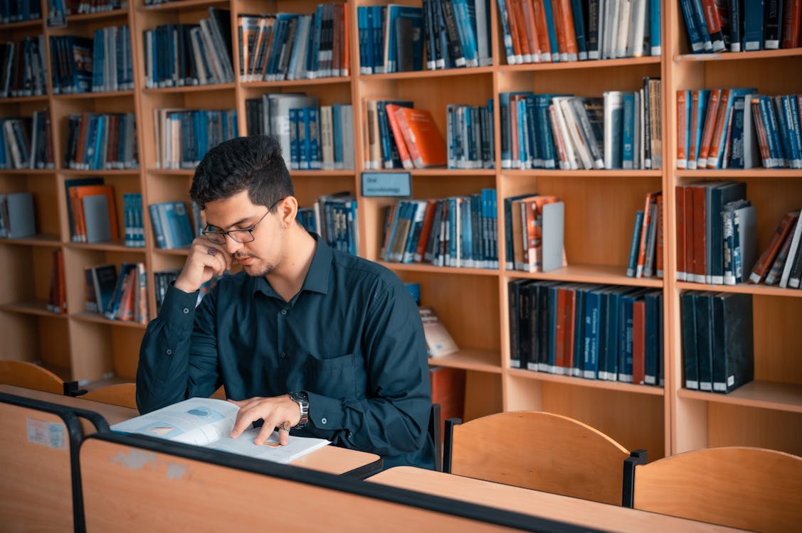 Man Reading a Book Inside the Library · Free Stock Photo Man Reading a Book Inside the Library · Free Stock Photo