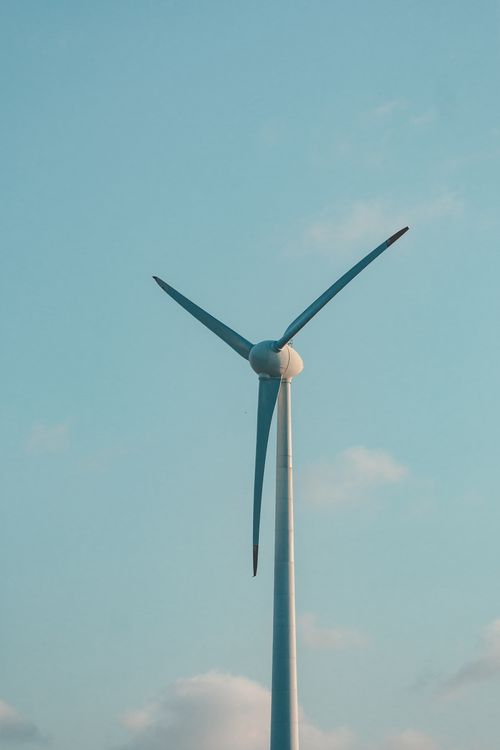 Free A towering wind turbine set against a clear blue sky, symbolizing renewable energy. Stock Photo