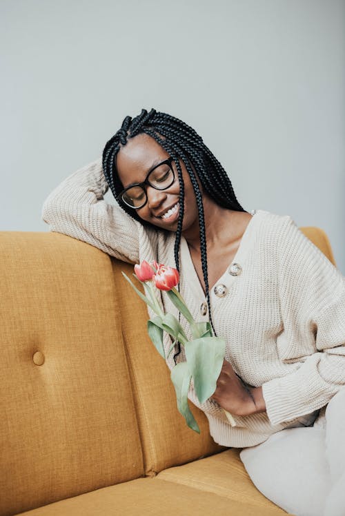 Black woman with flowers on couch