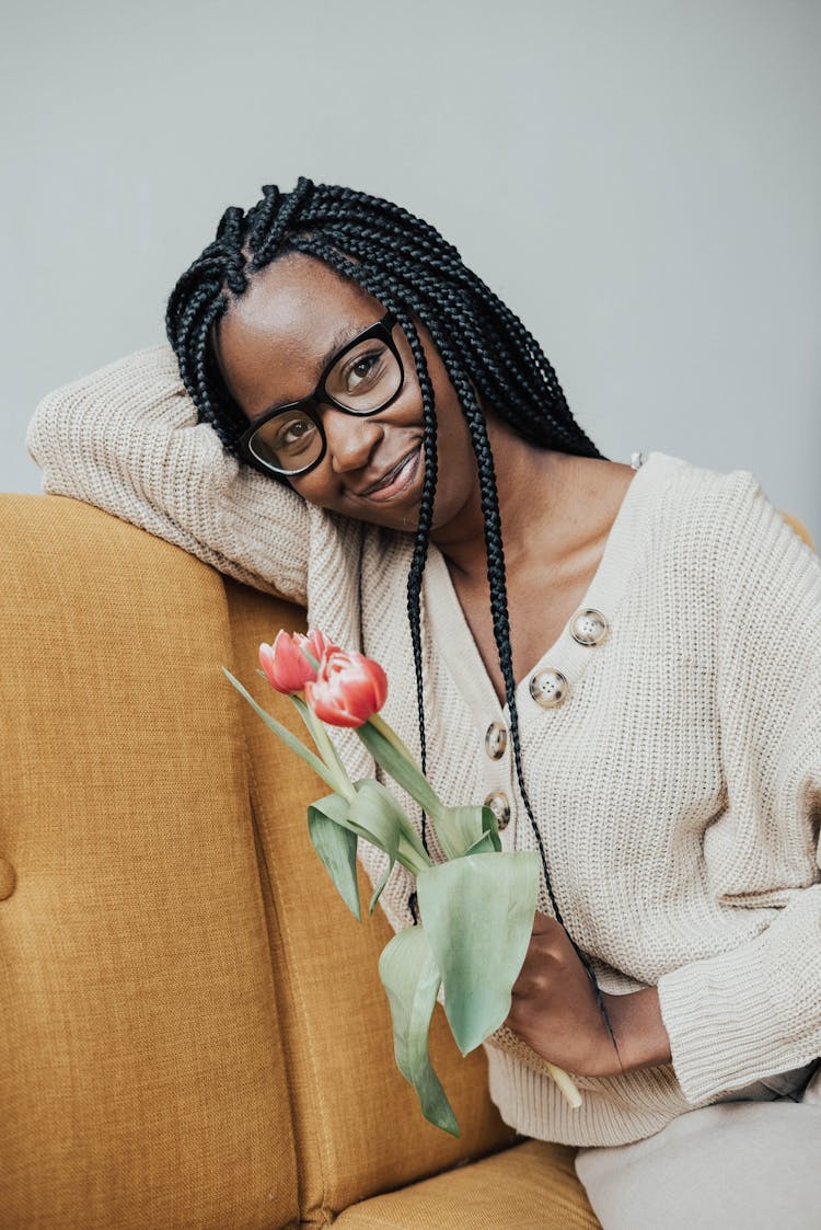 Smiling African American Woman On Couch With Flowers