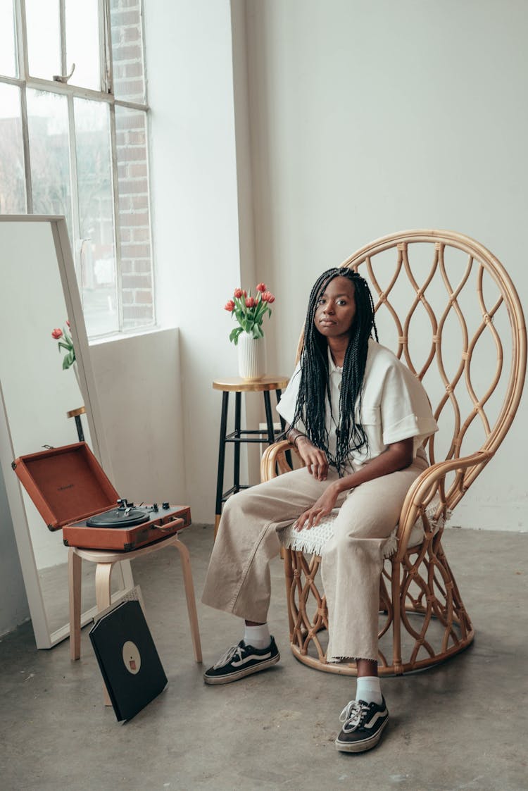 Cool Young Ethnic Woman Sitting Near Vinyl Record Player At Home