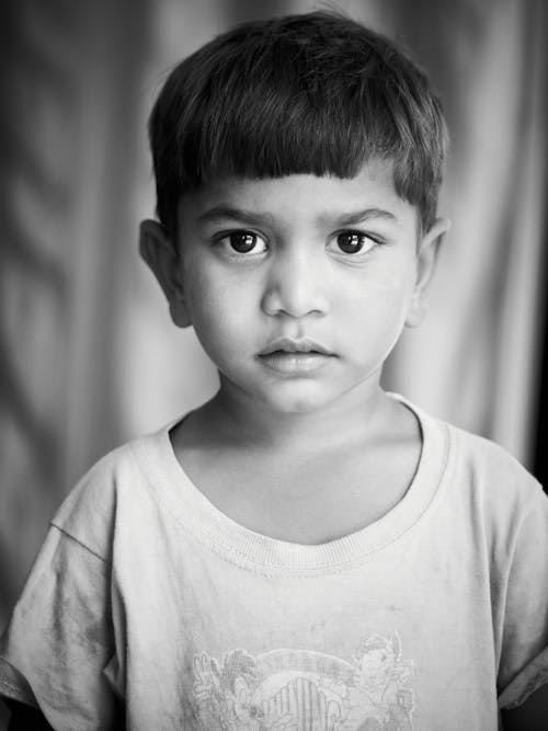 Monochrome Photo of a Cute Boy Looking at Camera