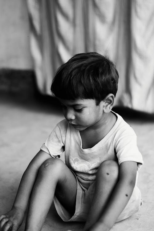 Free Monochrome Photo of Boy Sitting Down on the Floor Stock Photo