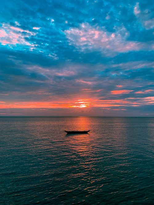 Silhouette of a Boat in the Ocean during Sunset · Free Stock Photo
