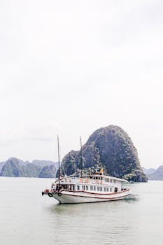Elegant boat cruising through Halong Bay's stunning limestone islands.