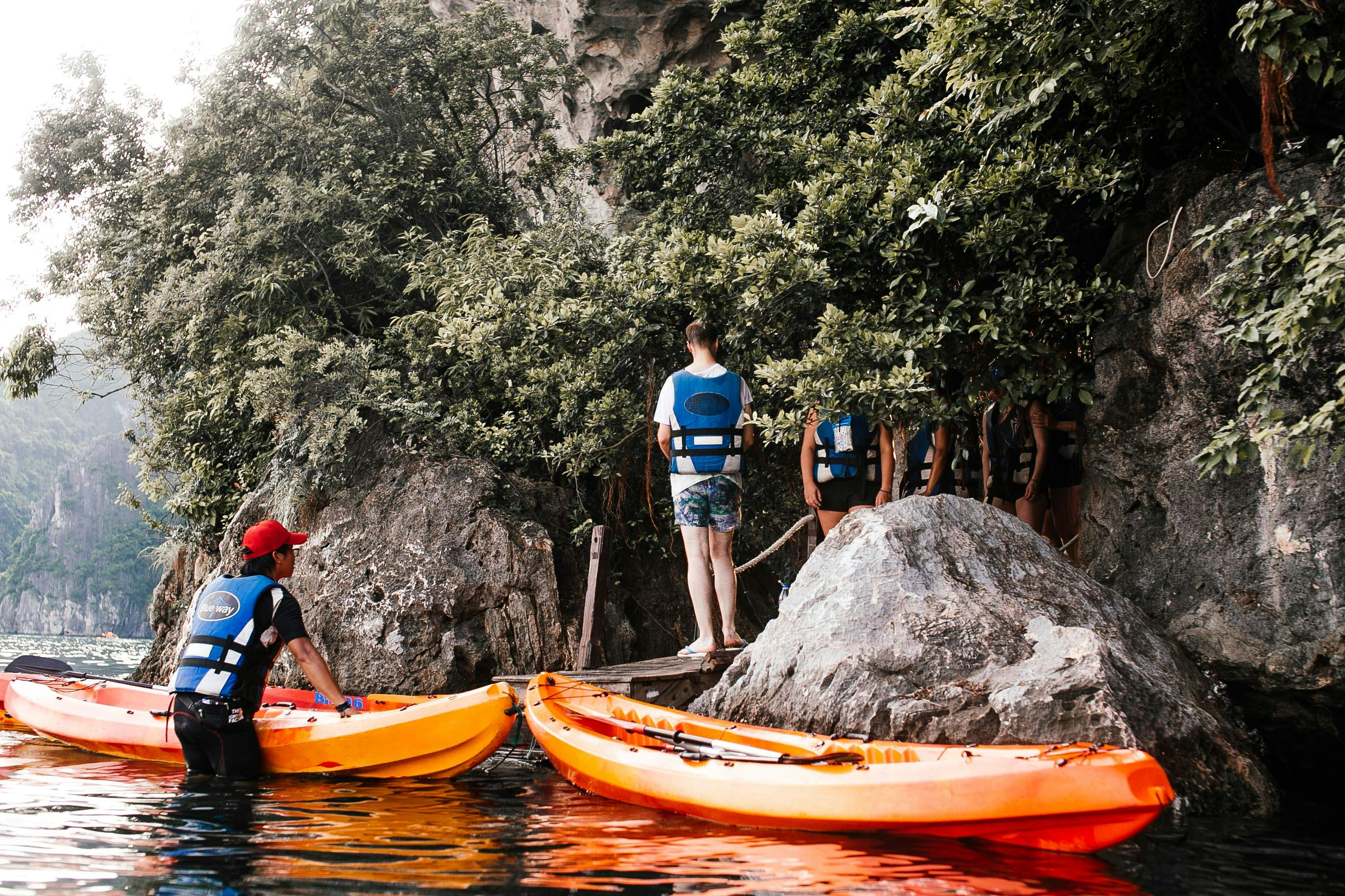 People with Canoes near Rocks on Riverbank · Free Stock Photo