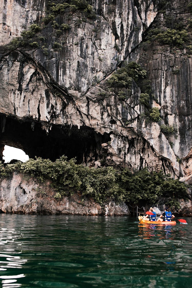 People Kayaking Near A Limestone Karst In Ha Long Bay