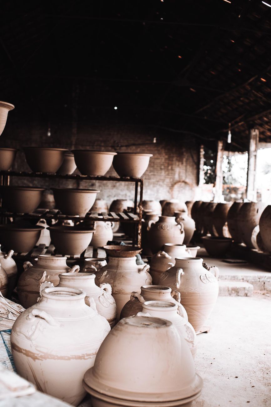 Explore a rustic ceramic workshop filled with handcrafted clay pots and bowls, showcasing traditional pottery techniques.