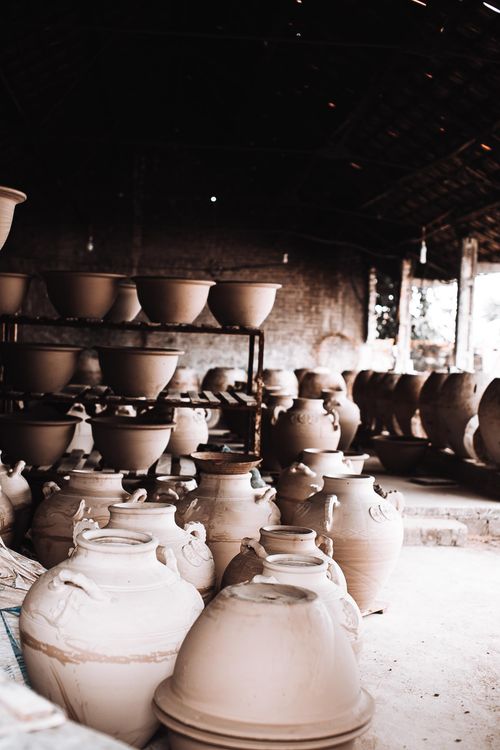 Free Explore a rustic ceramic workshop filled with handcrafted clay pots and bowls, showcasing traditional pottery techniques. Stock Photo