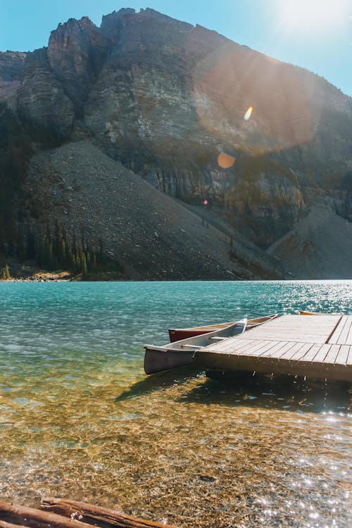 Free Rocky Mountain and Sun Reflecting in a Lake Stock Photo