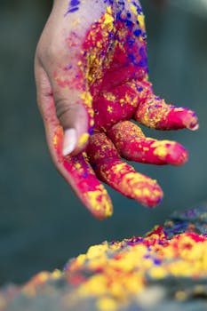 Close-up of a hand covered in colorful Holi powder, symbolizing celebration and joy.