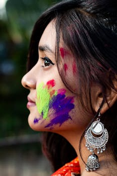 Vibrant portrait of a woman celebrating Holi with colorful powder on her face.