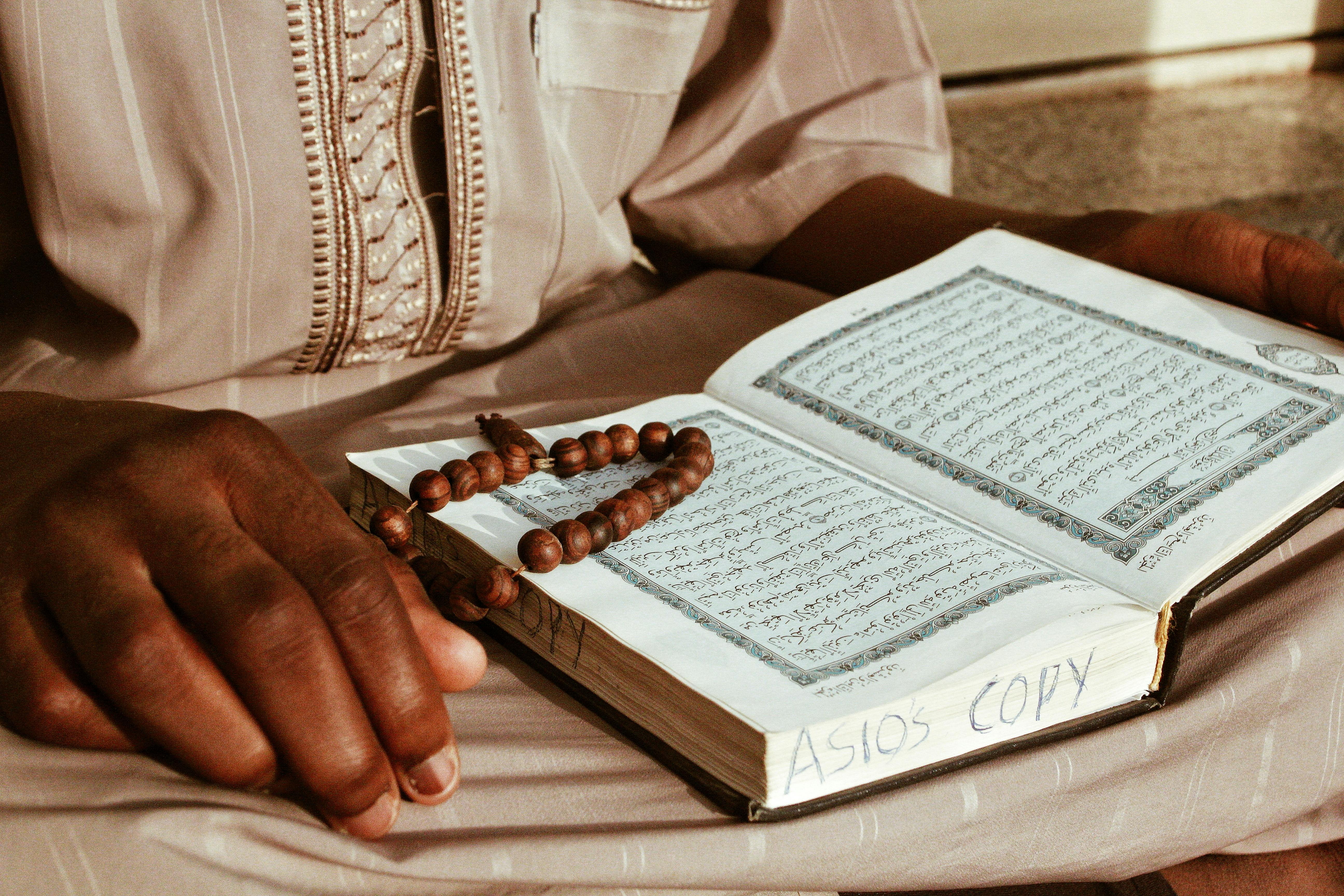 black man reading quran during religious ceremony