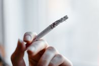 Fingers Holding Lighted Cigarette Stick