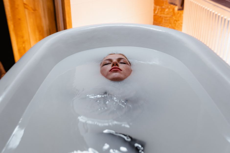 Cold Plunge Tubs: Benefits, Risks, and Best Options for Recovery A woman floating peacefully in a bathtub, creating a serene and calming atmosphere.