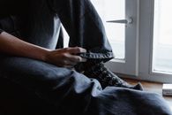 Hand Holding Bottom Hem of Denim Jeans