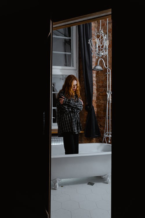 A Lonely Woman Standing in a Bathtub