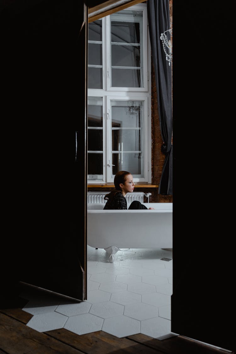 Woman On White Bathtub With Clothes On