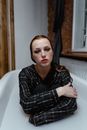 Woman in White Bathtub with Black and White Plaid Shirt