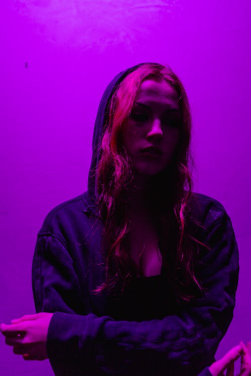 Free Woman in a Hoodie in Purple Light Stock Photo