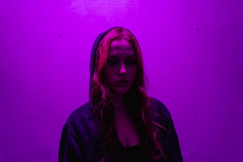 Free Woman in a Hoodie in Purple Light Stock Photo