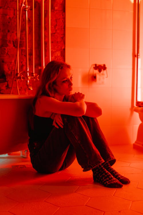 Free A Woman Sitting Beside a Bathtub Stock Photo