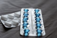 Detailed view of medication in blister packs showcasing blue softgel capsules and white pills.