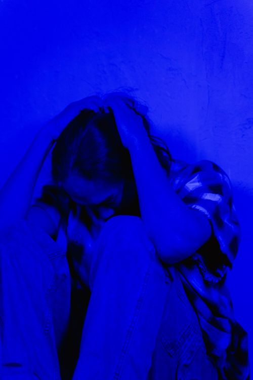 Man sitting alone on the floor overwhelmed by distress — PTSD can leave survivors feeling isolated, hopeless, and unable to move forward