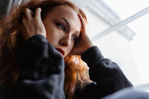 Close-Up Photo of a Pensive Woman in Black Long Sleeve Shirt