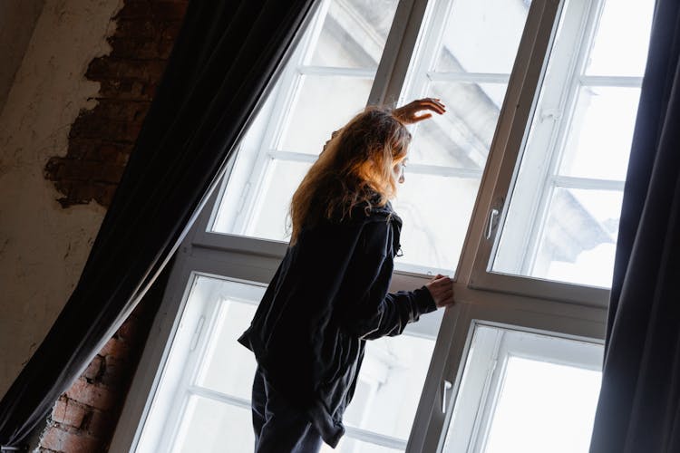 Woman Looking Outside A Window