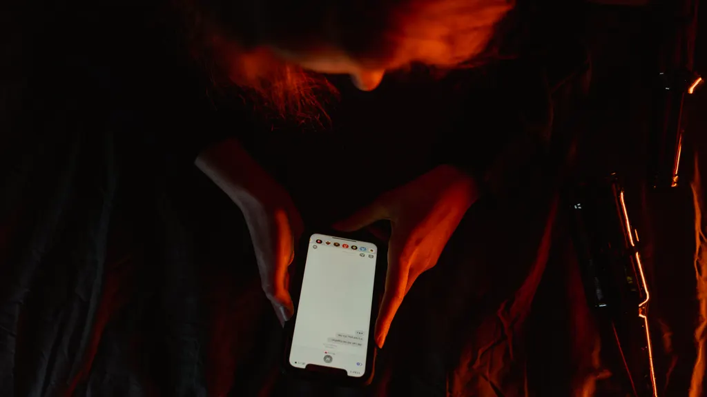 Person using a smartphone in dim lighting