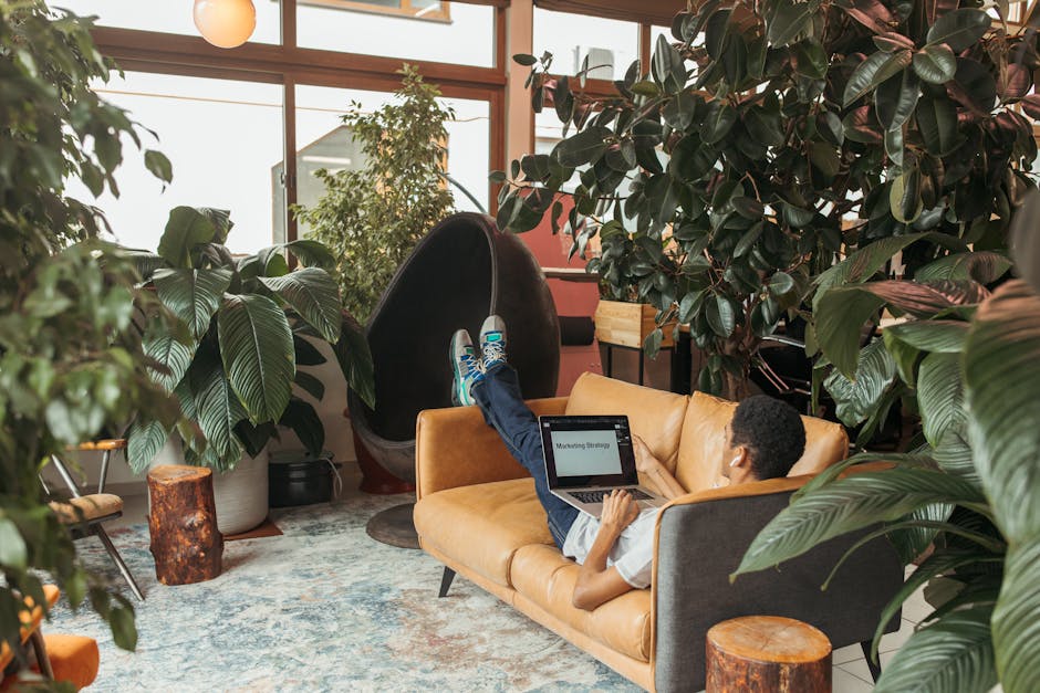 A Man Using a Laptop while Lying on the Couch 