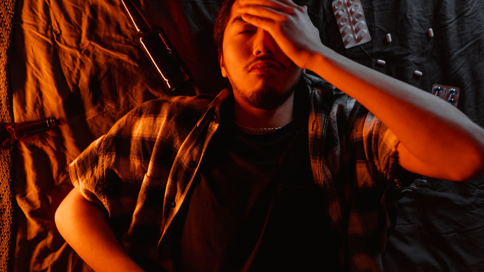Man lying down with his hand on his face, looking worried