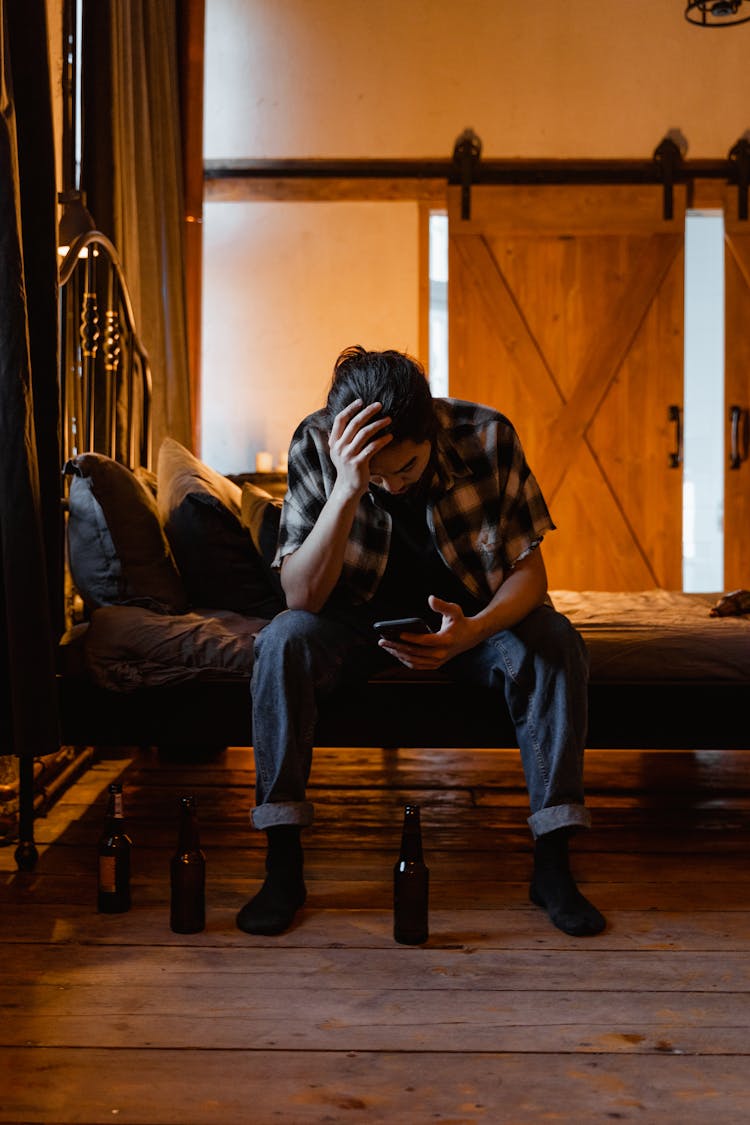 Tired Man Sitting On The Bed