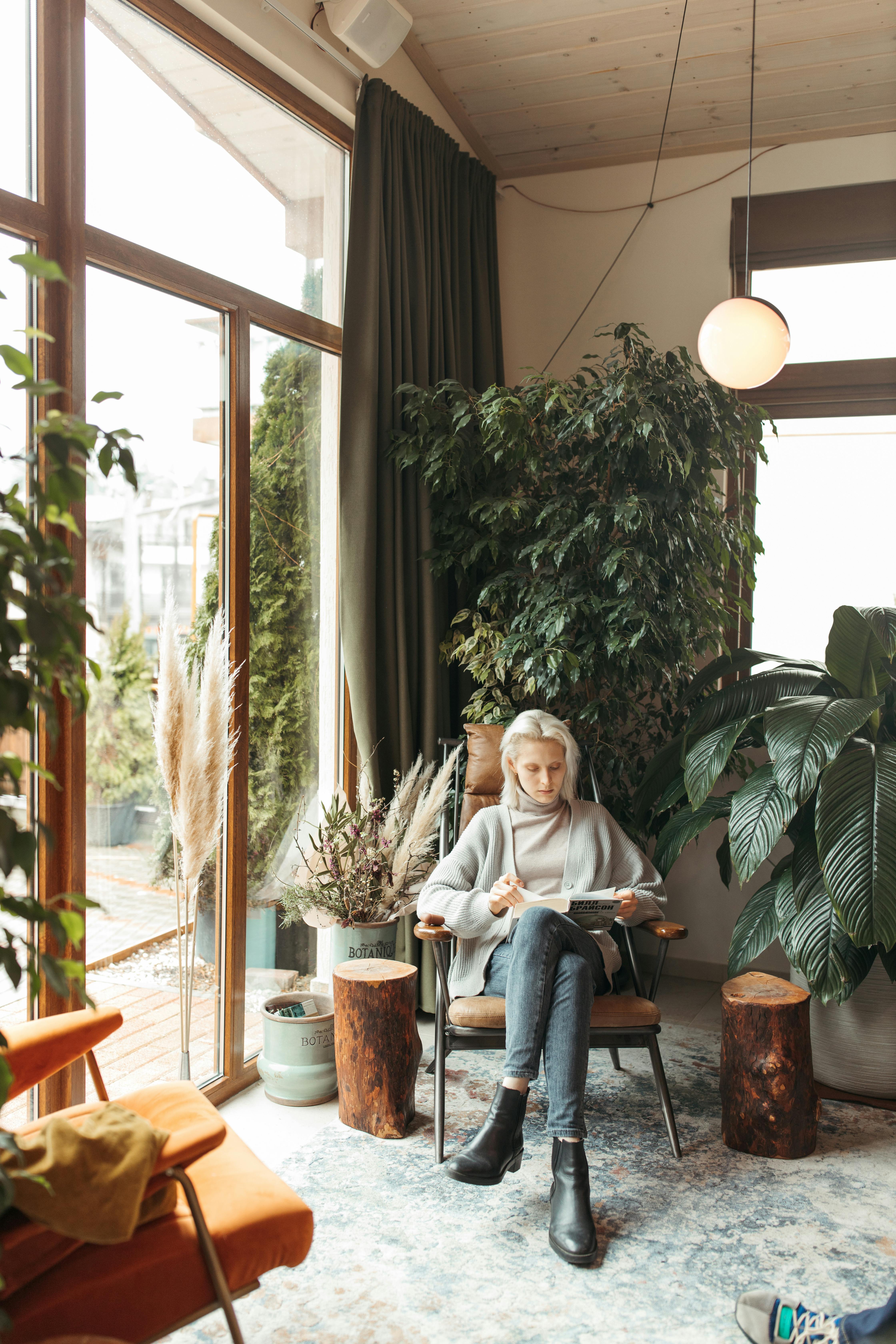 Free A contemporary office space with a woman working amidst plants and natural light. Stock Photo